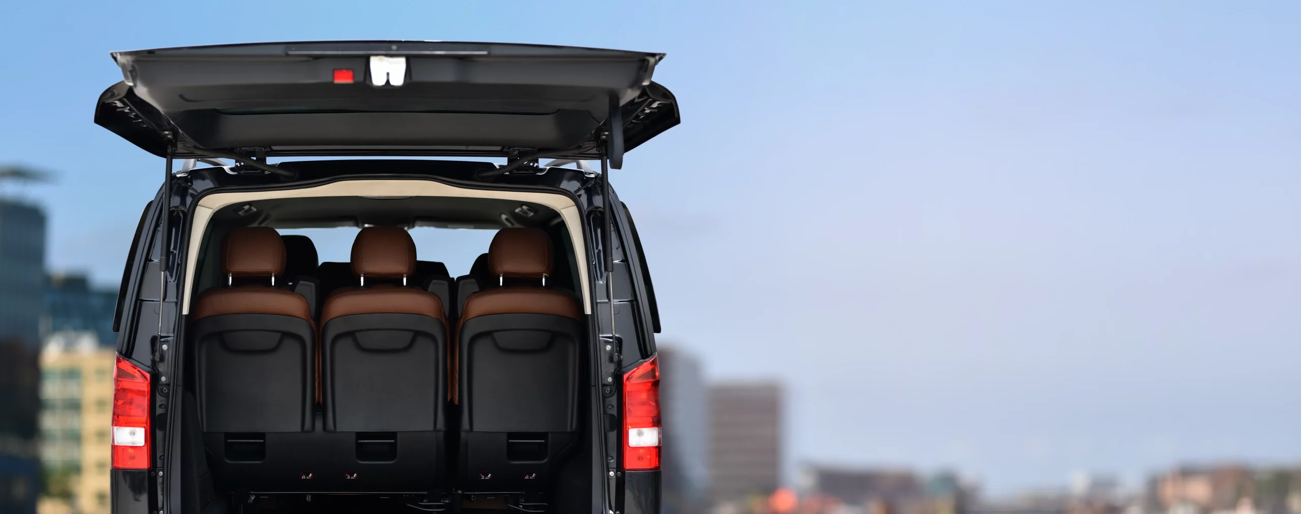 Driver loads luggage into a private transfer van — interior view of the cabin